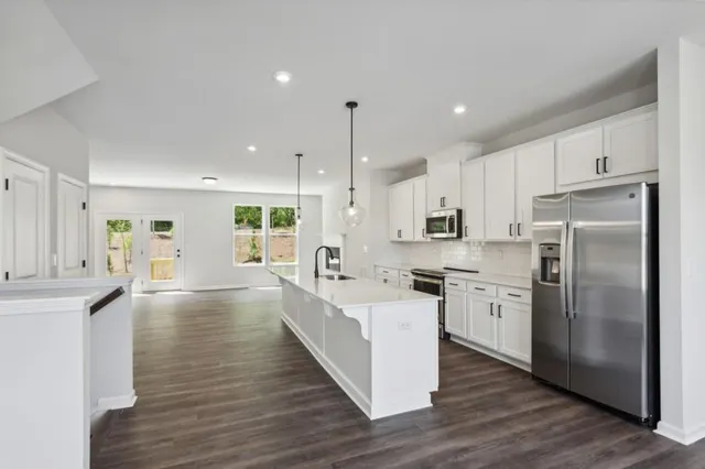 a large kitchen with stainless steel appliances granite countertop a lot of counter space and wooden floors