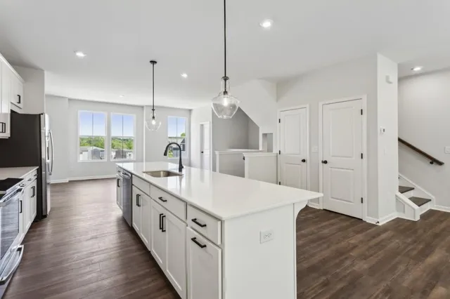 a large kitchen with kitchen island white cabinets and stainless steel appliances