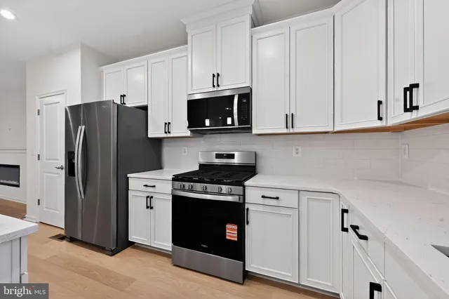 a kitchen with white cabinets and stainless steel appliances