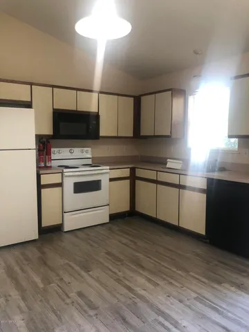 a kitchen with stainless steel appliances granite countertop a sink a stove a refrigerator with grey cabinets