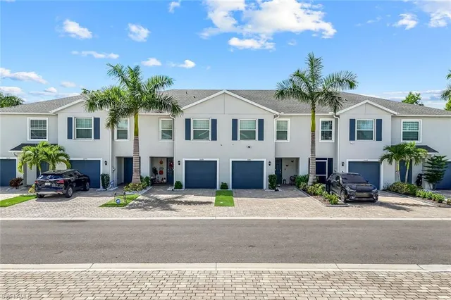 a front view of a house with yard and parking
