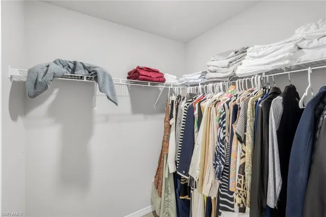 a view of walk in closet with clothes and shoes