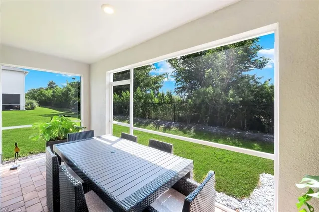 a view of a patio with a table chairs and a yard