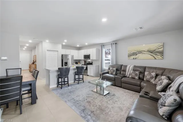 a living room with furniture and a dining table with kitchen view
