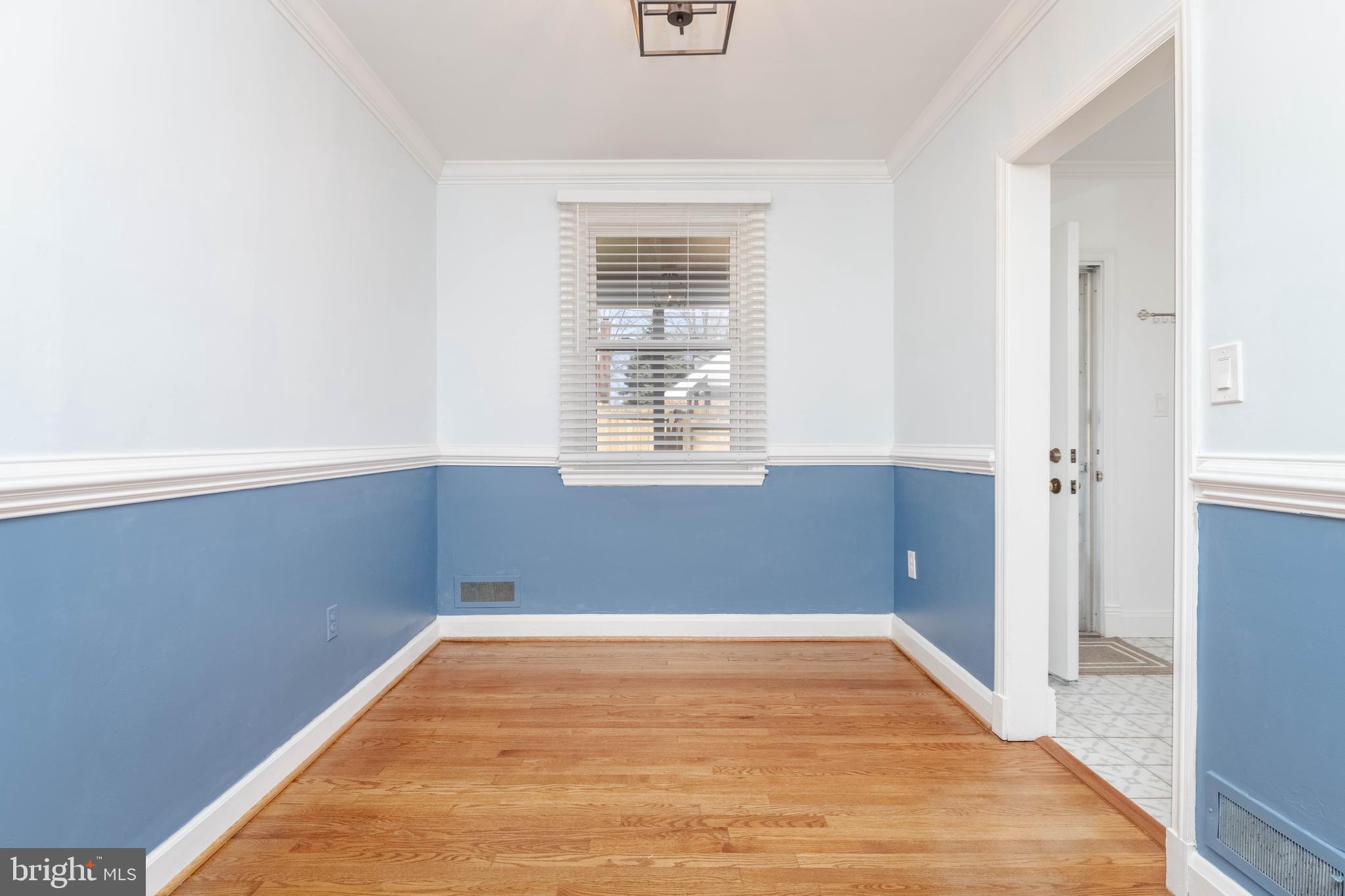 7012 Dunhill Road Dundalk, MD 21222 - Photo 11 of 38 a view of an empty room with wooden floor and a window