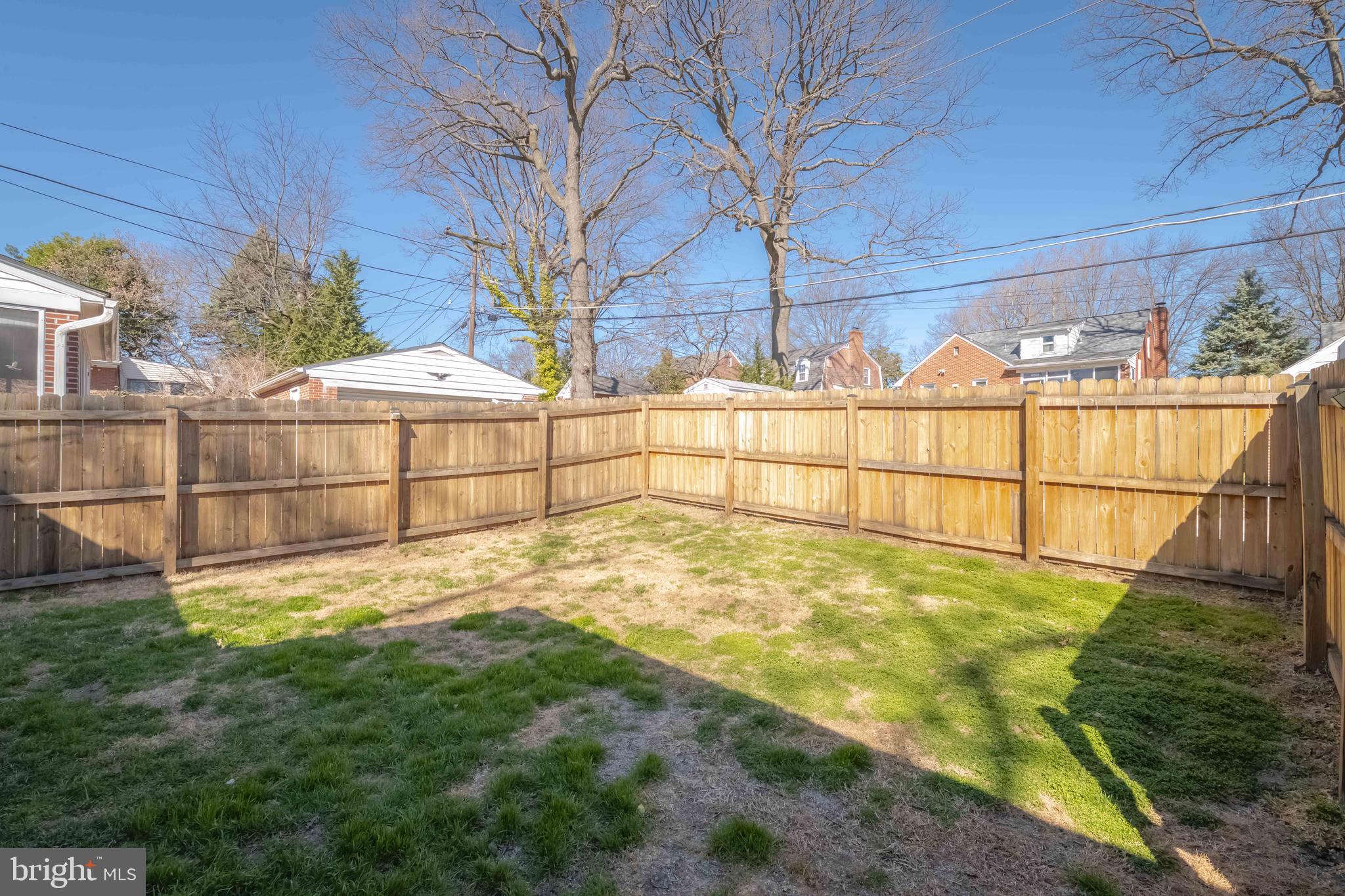 7012 Dunhill Road Dundalk, MD 21222 - Photo 32 of 38 a view of backyard with large tree and wooden fence
