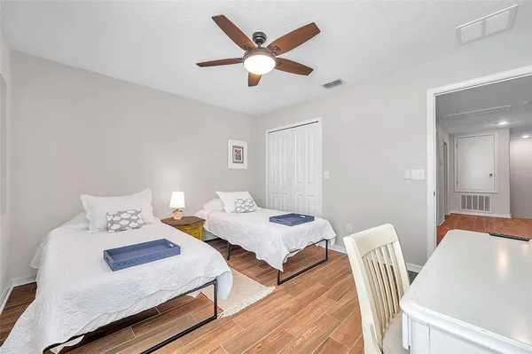 a bedroom with two beds and a potted plant