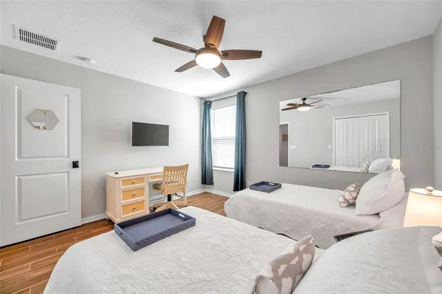 a bedroom with two beds and a potted plant
