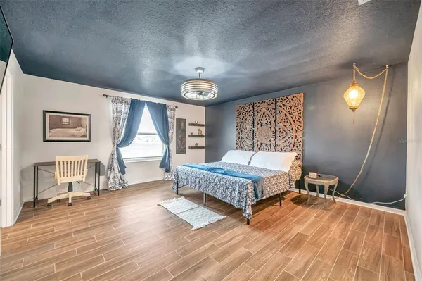 a spacious bedroom with a bed and a chandelier