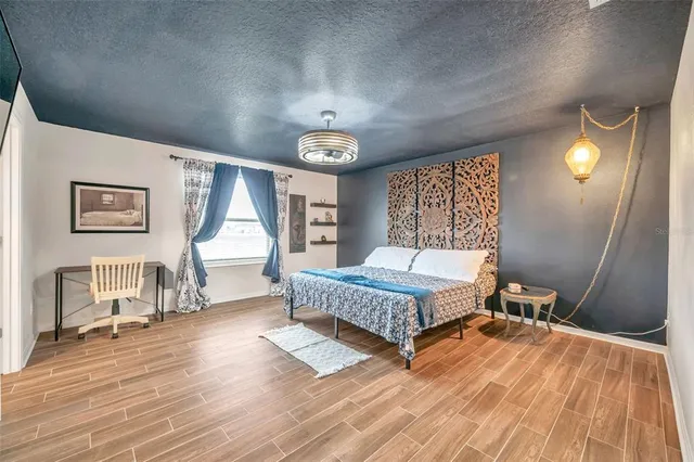 a spacious bedroom with a bed and a chandelier