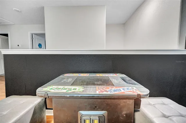 a open kitchen with stainless steel appliances granite countertop a stove top oven a refrigerator a sink and a dining table with wooden floor