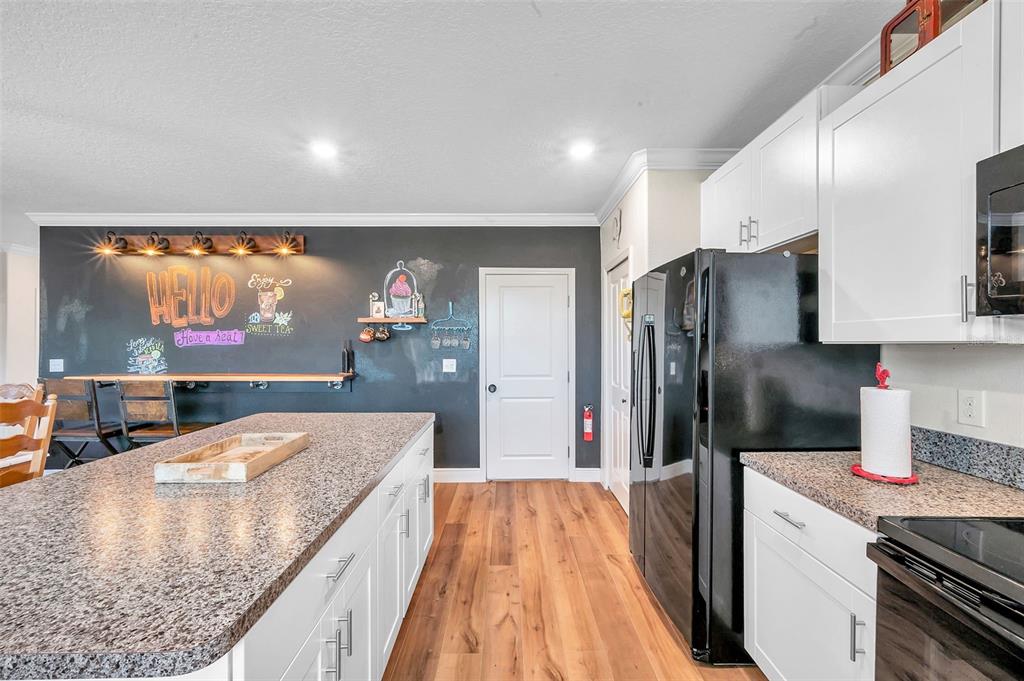 3737 Copperspring Boulevard New Port Richey, FL 34653 - Photo 39 of 61 a kitchen with stainless steel appliances granite countertop a refrigerator a stove and a sink with wooden floor
