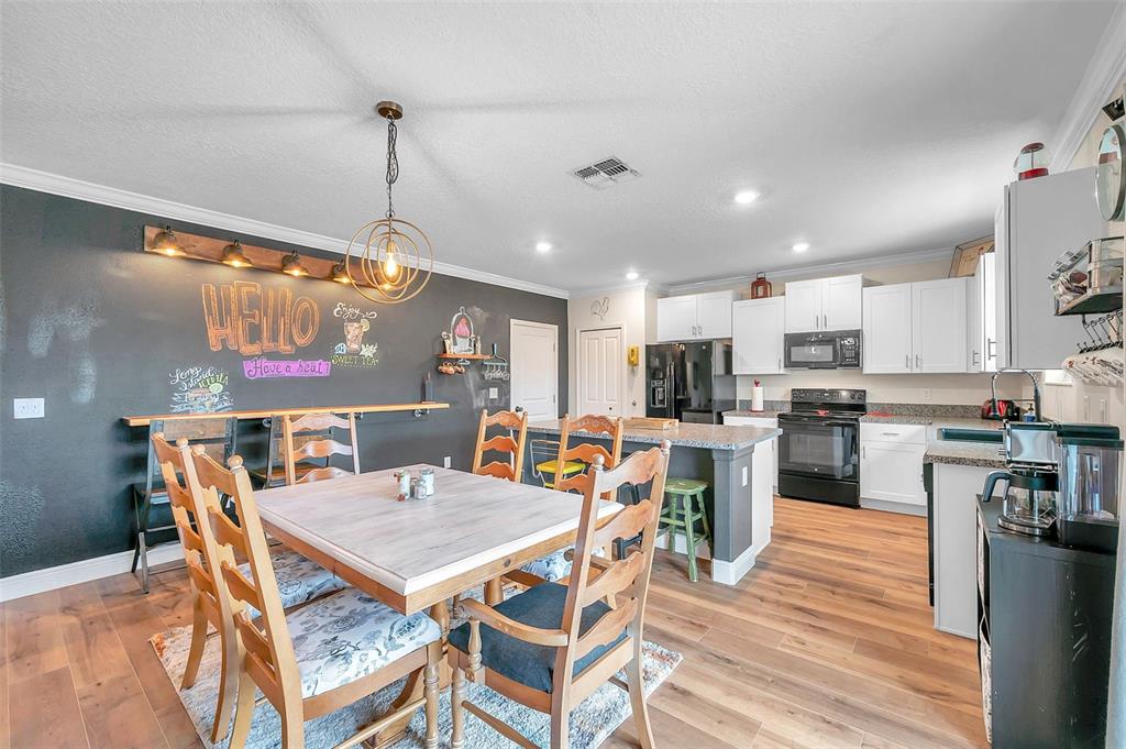 3737 Copperspring Boulevard New Port Richey, FL 34653 - Photo 40 of 61 a open kitchen with stainless steel appliances granite countertop a stove top oven a refrigerator a sink and a dining table with wooden floor