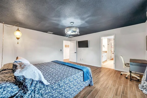 a bedroom with a large bed and a chandelier