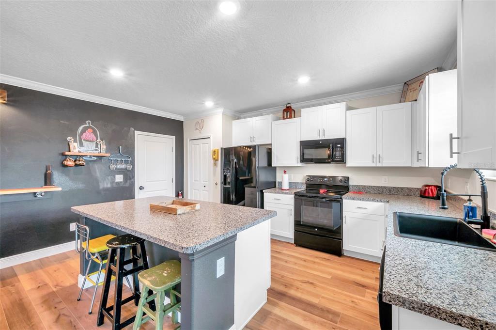 3737 Copperspring Boulevard New Port Richey, FL 34653 - Photo 43 of 61 a kitchen with stainless steel appliances granite countertop a stove top oven a sink a dining table and chairs with wooden floor