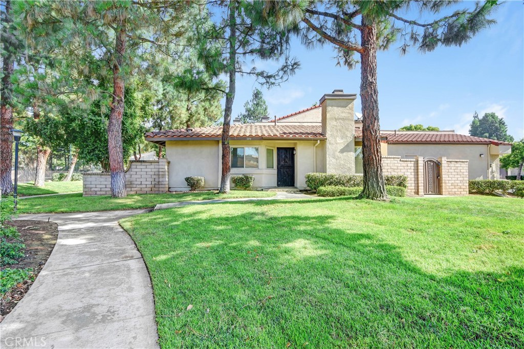 7858 Peralta Road Rancho Cucamonga, CA 91730 - Photo 1 of 14 a front view of a house with a garden and yard
