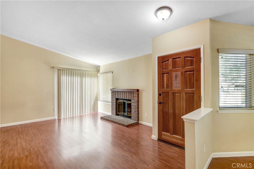 7858 Peralta Road Rancho Cucamonga, CA 91730 - Photo 4 of 14 a view of a livingroom with wooden floor and fireplace
