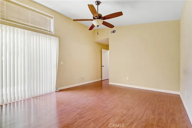 a view of room with a ceiling fan and wooden floor