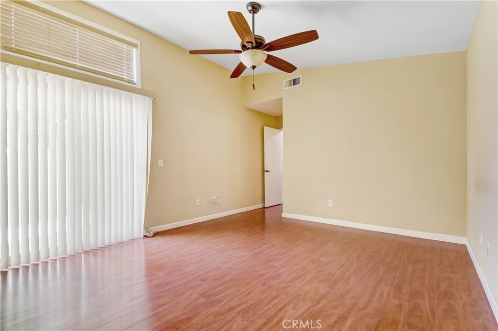 7858 Peralta Road Rancho Cucamonga, CA 91730 - Photo 8 of 14 a view of room with a ceiling fan and wooden floor