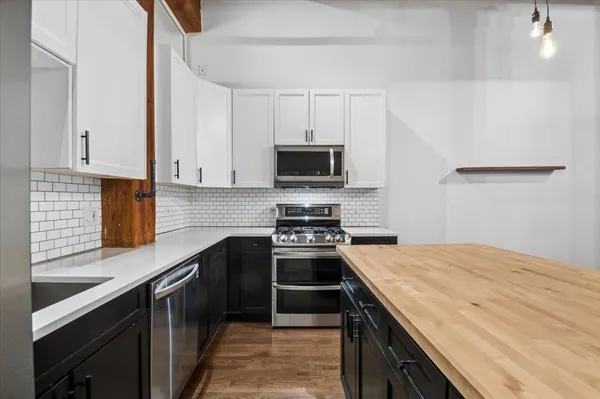 a kitchen with a sink a stove and wooden floor