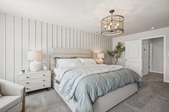 a bedroom with a bed and a chandelier