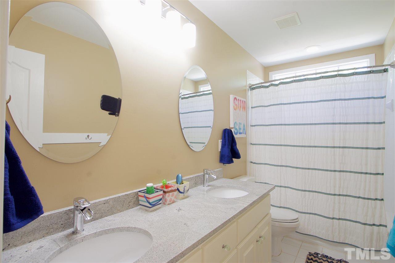 8208 Gadsen Court Raleigh, NC 27613 - Photo 22 of 25 a bathroom with a granite countertop sink and a mirror