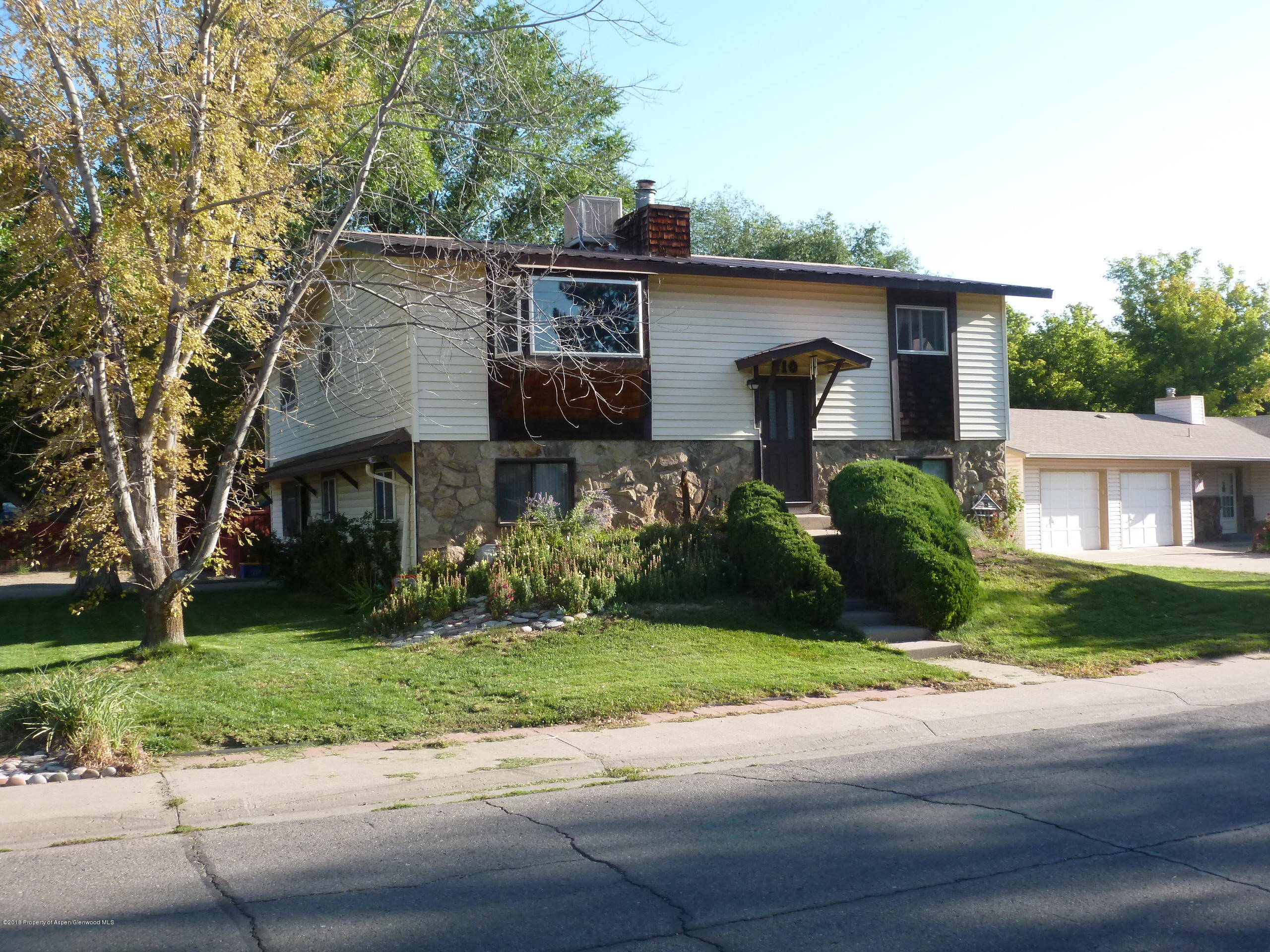 810 East 5th Street Rifle, CO 81650 - Photo 1 of 13 a front view of a house with a yard and a garage