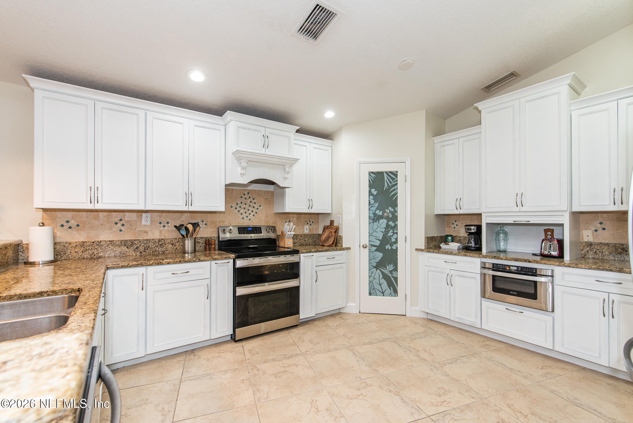 35 Oak Street St. Augustine, FL 32084 - Photo 28 of 43 a kitchen with white cabinets and appliances