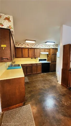 a view of a room with kitchen island stainless steel appliances wooden floor and living room view