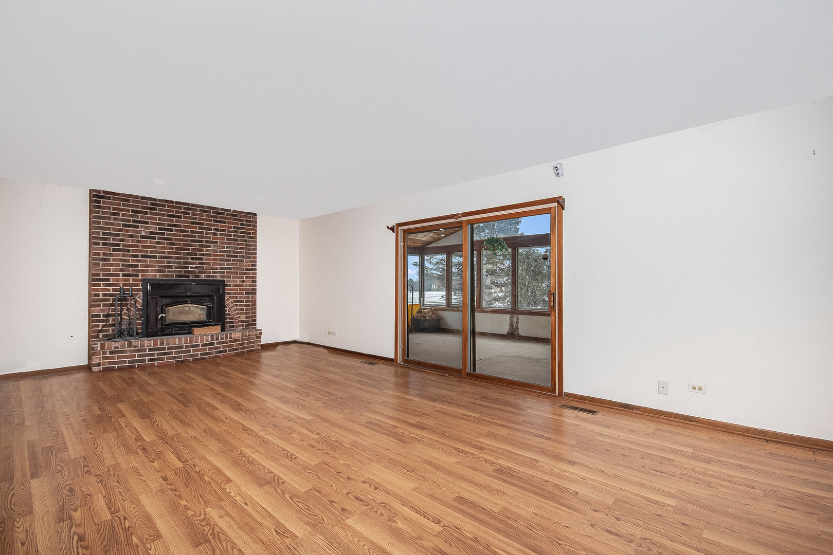 2880 Sun Valley Road Lisle, IL 60532 - Photo 9 of 29 an empty room with wooden floor and a fireplace