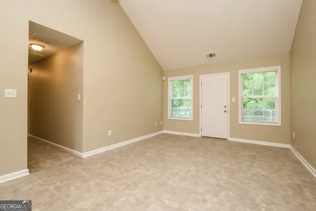 an empty room with windows and closet