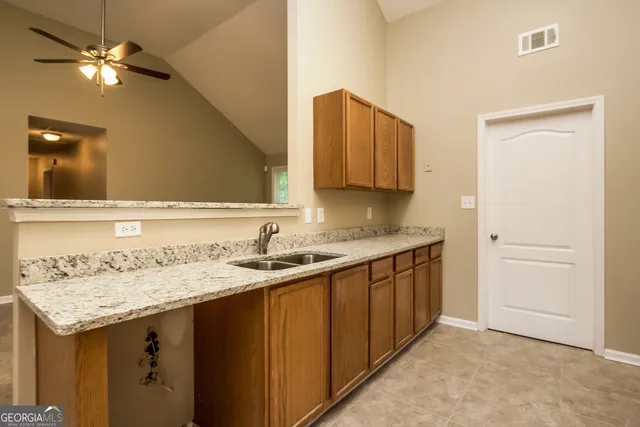 a kitchen with a sink a cabinetry and a refrigerator