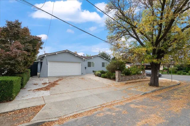 a view of a house with a yard and tree