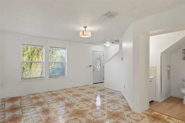 a view of a big room with wooden floor and windows