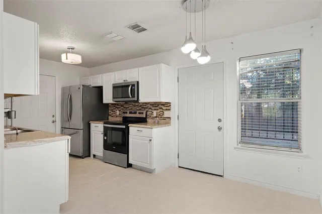 a kitchen with stove cabinets and refrigerator