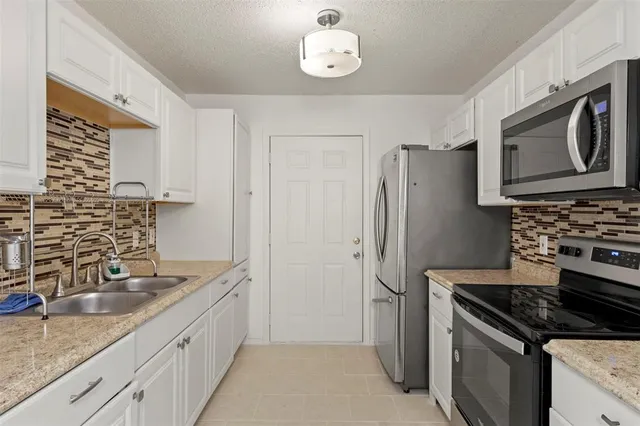a kitchen with granite countertop a stove and a refrigerator