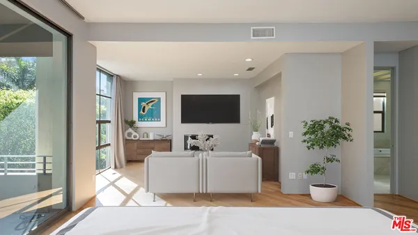 a living room with furniture potted plant and a large window