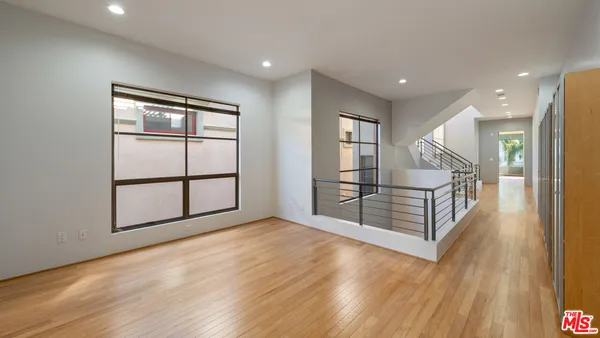 a view of a big room with wooden floor and windows