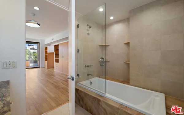 an empty room with wooden floor cabinet and windows