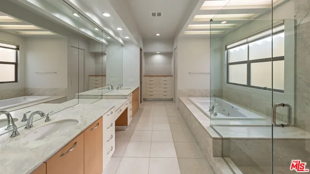 a bathroom with a granite countertop sink a large mirror and shower