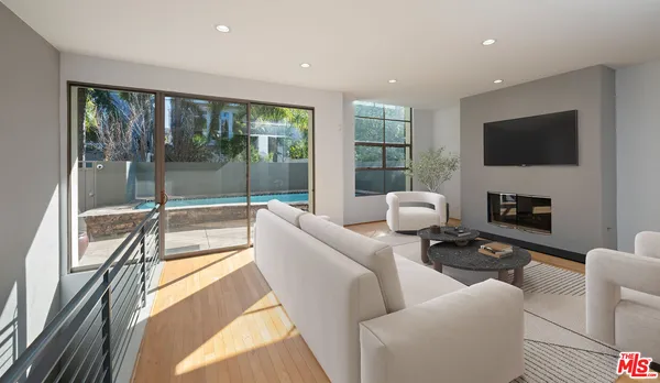 a living room with furniture a flat screen tv and a floor to ceiling window
