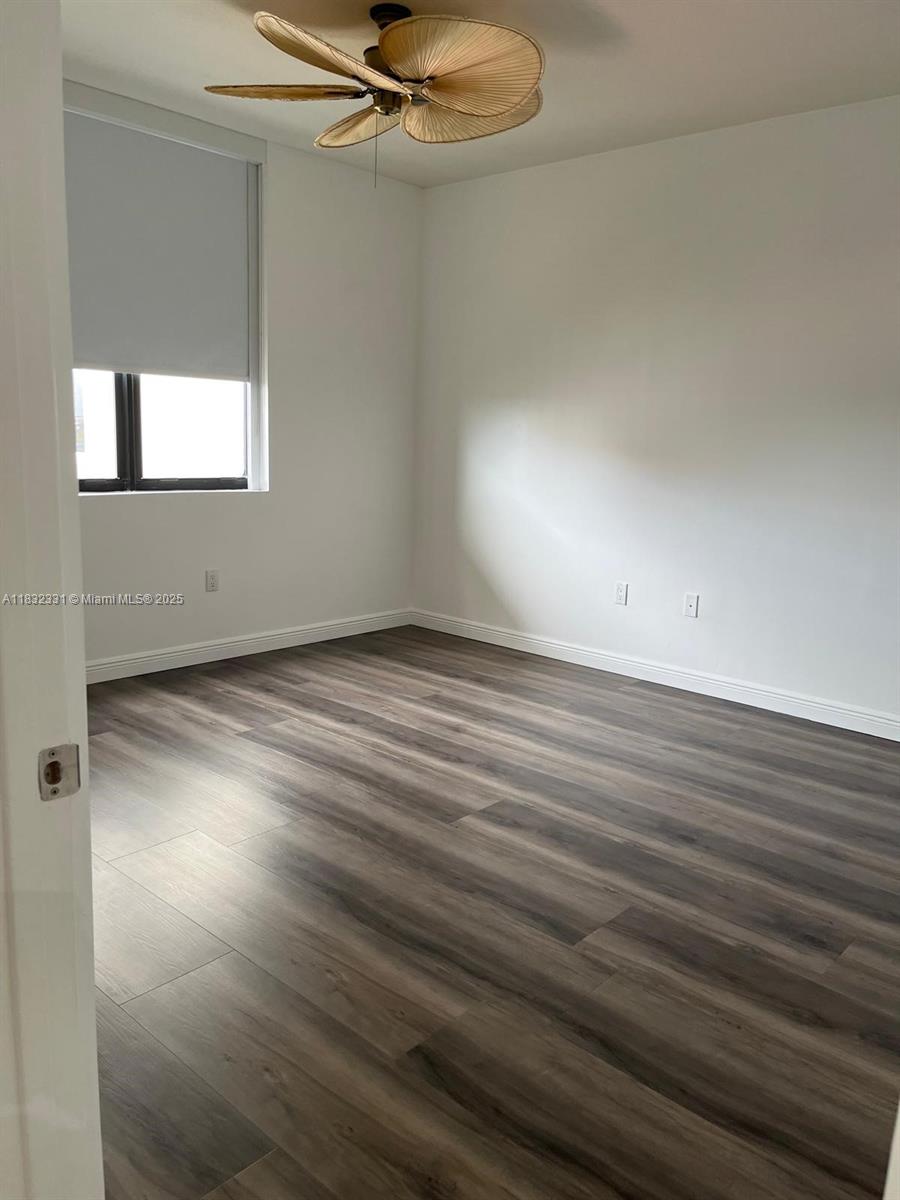 Central Gables Coral Gables, FL 33134 - Photo 7 of 11 an empty room with wooden floor fan and windows