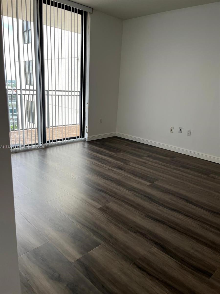 Central Gables Coral Gables, FL 33134 - Photo 8 of 11 an empty room with wooden floor and windows