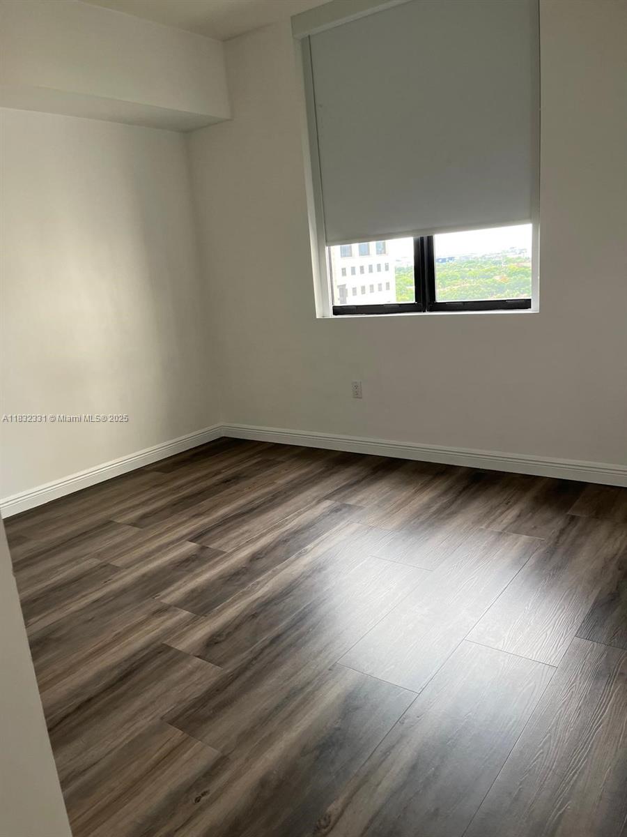 Central Gables Coral Gables, FL 33134 - Photo 9 of 11 an empty room with wooden floor and windows
