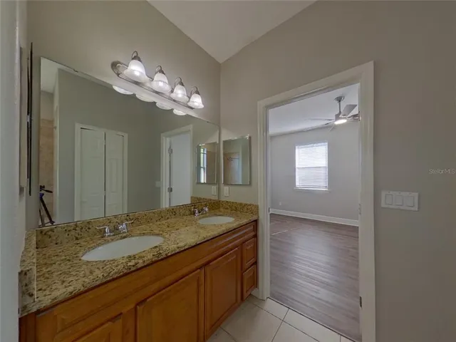 a bathroom with a granite countertop sink and a mirror