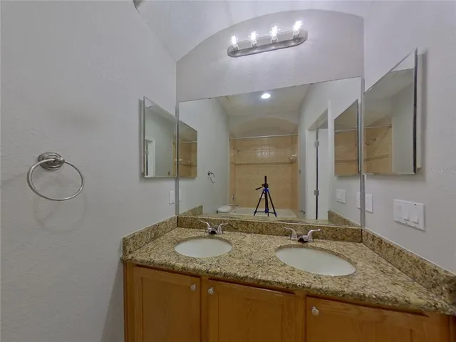 a bathroom with a granite countertop sink and a mirror