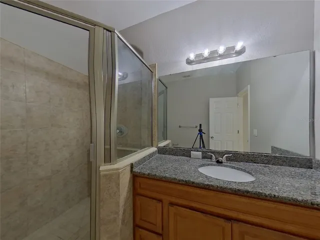 a bathroom with a granite countertop sink and a mirror