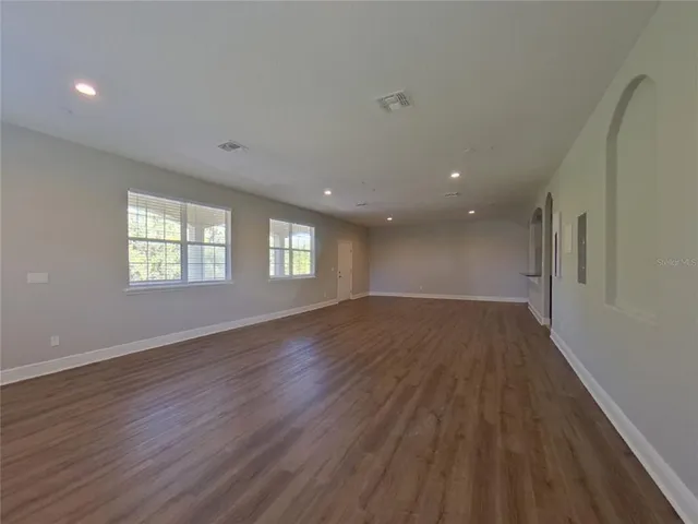 a view of empty room with window and wooden floor