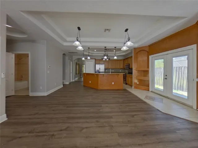 a big room with chandelier fan and windows