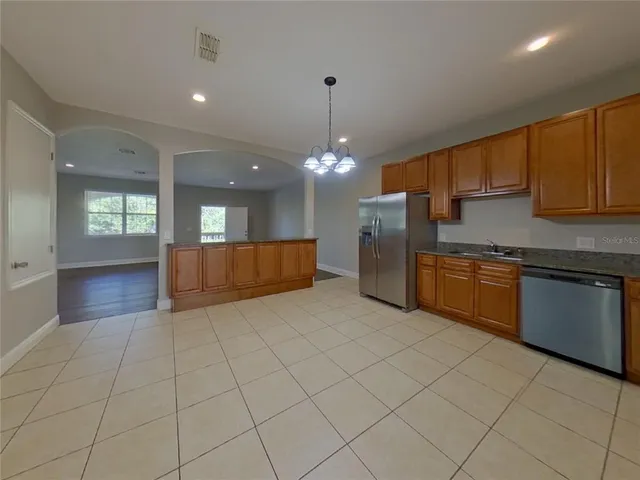 a kitchen with stainless steel appliances granite countertop a stove a sink and a refrigerator